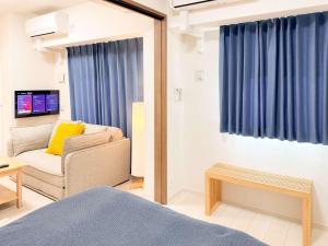 a room with a bed and a couch and a chair at Triphome Tokyo Sugamo 2024 New 3 mins 2 stations in Tokyo