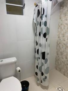 a bathroom with a toilet and a shower curtain at Mar Azul A&K - Sol e Mar in Penha +8 photos
