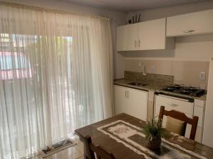 a kitchen with a table and a kitchen with a window at Mar Azul A&K - Sol e Mar in Penha