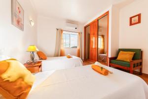 Una habitación de hotel con dos camas y una silla. en Villa Peace by Algarve Vacation, en Pêra