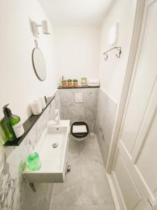 a white bathroom with a sink and a toilet at JoyJoyJoy the Green Palm ecolicious studio in a in historic Canalhouse from 1729 with view on the canals in Amsterdam