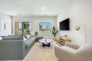 a living room with two couches and a tv at Indio Retreat by VARE Pool Spa Putting Green in Indio