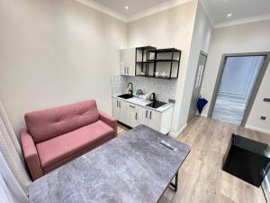 a living room with a red chair and a table at MegaPark Appartments in Almaty +21 photos