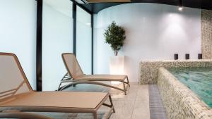 two chairs sitting next to a swimming pool at VacationClub - Baltic Waves Resort Apartament A109 in Międzyzdroje