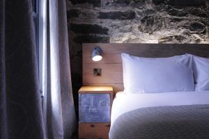 a bedroom with a bed with a brick wall at Suie Hunting Lodge in Killin