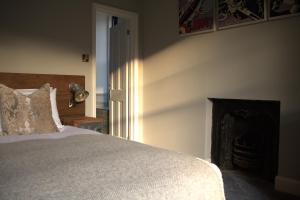 a bedroom with a bed and a fireplace at Suie Hunting Lodge in Killin