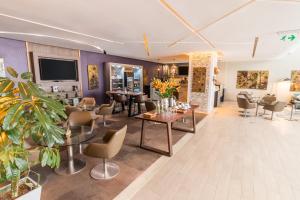 a living room with tables and chairs and a tv at Sonesta Hotel Arequipa in Arequipa