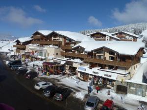 a ski lodge with cars parked in a parking lot at Les Saisies Appartement 3 Pièces 8 Pers. avec 2 SDB et Garage - FR-1-293-275 in Hauteluce