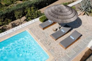 an overhead view of a swimming pool with an umbrella and chairs at Agapui-Peaceful Retreat with Amazing Views in Naxos Chora