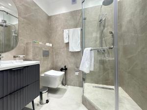 a bathroom with a shower and a toilet and a sink at MegaPark Appartments in Almaty