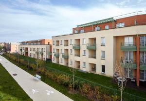 a row of apartment buildings with a sidewalk at B&B HOTEL Bois d'Arcy Saint Quentin en Yvelines in Bois-dʼArcy