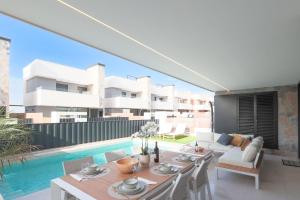 a living room with a table and a swimming pool at Villa Almendro Santa Rosalia Lake and Life Resort by PREMIUM SPAIN PROPERTIES in Torre-Pacheco
