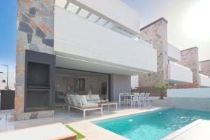 a house with a swimming pool and a patio at Villa Almendro Santa Rosalia Lake and Life Resort by PREMIUM SPAIN PROPERTIES in Torre-Pacheco