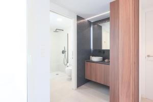 a bathroom with a sink and a toilet and a mirror at Villa Almendro Santa Rosalia Lake and Life Resort by PREMIUM SPAIN PROPERTIES in Torre-Pacheco