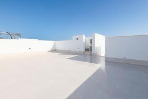 a large white building with a blue sky in the background at Villa Almendro Santa Rosalia Lake and Life Resort by PREMIUM SPAIN PROPERTIES in Torre-Pacheco