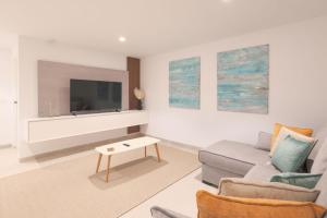 a living room with a couch and a tv at Villa Almendro Santa Rosalia Lake and Life Resort by PREMIUM SPAIN PROPERTIES in Torre-Pacheco