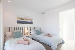 two beds with towels on them in a bedroom at Villa Almendro Santa Rosalia Lake and Life Resort by PREMIUM SPAIN PROPERTIES in Torre-Pacheco