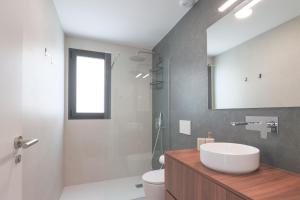 a bathroom with a sink and a toilet and a mirror at Villa Almendro Santa Rosalia Lake and Life Resort by PREMIUM SPAIN PROPERTIES in Torre-Pacheco