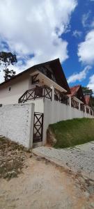 a white building with a fence in front of it at Chalé Serrano in Guaramiranga +15 photos