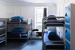 a room with three bunk beds and a window at Bath Backpackers in Bath