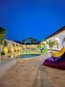 una piscina nel mezzo di un cortile di notte di Jancoox Hostel a Kuta Lombok