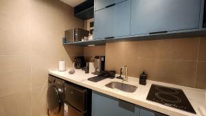 a small kitchen with a sink and a dishwasher at Em frente à praia - conforto, localização e vista in Rio de Janeiro +14 photos