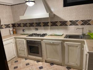 a kitchen with a stove and a sink at Domus Martinae in Casal Palocco