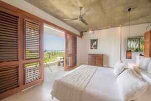 Un dormitorio con una cama blanca y una ventana grande. en Casa Phil - Amazing Sea View Luxury Modern, Fully Staffed, en Las Terrenas