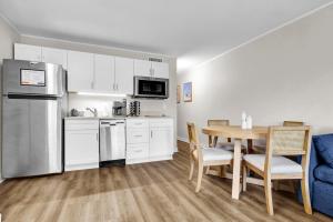 cocina y comedor con mesa y nevera en Summer Sands - 108 by Sea Scape Properties, en Wrightsville Beach