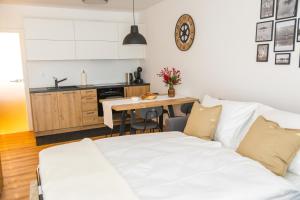 a living room with a white couch and a kitchen at Skalca Serenity Apartments Bled in Bled