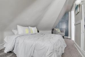una camera da letto bianca con un letto bianco e una sedia di G6 central location museums FREE PARKING a Richmond