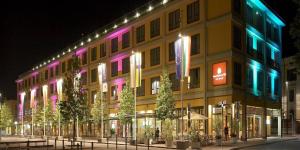 un edificio con luci colorate sul lato di Grand Hotel De La Ville a Parma