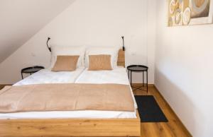 a bedroom with a white bed with two tables at Skalca Serenity Apartments Bled in Bled