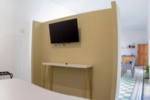 a bedroom with a tv on a wall with a bed at Casa Monarcas - Victoria (with AC) in Guadalajara