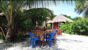 a table with blue chairs in front of a house at Abené shuDyma lodge in Abene