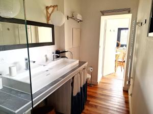 a bathroom with a white sink and a mirror at Le Clos du Palastre, à 10 mn de Vannes in Plescop