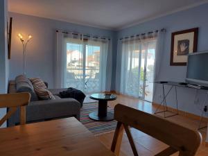 ein Wohnzimmer mit Sofa und Fernseher in der Unterkunft Bleu Soleil By Ericeira Property in Mafra