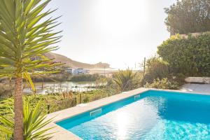 ein blauer Pool mit einer Palme im Hof in der Unterkunft Bleu Soleil By Ericeira Property in Mafra