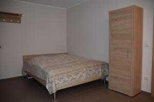 ein Schlafzimmer mit einem Bett und einem Holzschrank in der Unterkunft Ferienwohnung an der Obermosel in Oberbillig