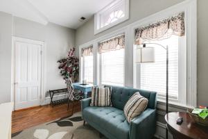 a living room with a blue couch and windows at Cozy studio in the FAN museums free parking in Richmond