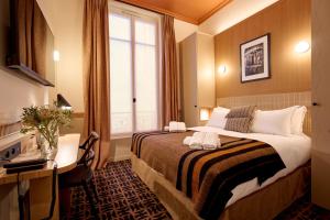 a hotel room with a bed and a desk and a window at 6 VH Hotel in Paris