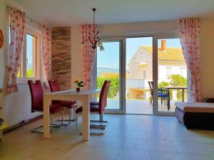 a living room with a table and chairs and a balcony at Villa Branka in Šilo