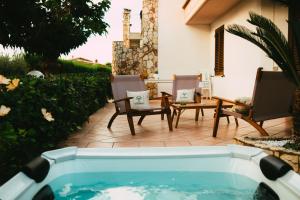 a swimming pool in a yard with chairs and a table at VillaThomas in Campofelice di Roccella