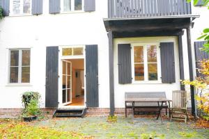 un portico di una casa bianca con panchina di Wohnensemble mit 3 separaten Bereichen- 2 Küchen- 3 Badezimmer- 10 Personen- Garten- Parkplatz a Wolfsburg