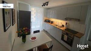 eine kleine Küche mit einer Vase mit Blumen auf einer Theke in der Unterkunft H4 Family apartment, central, quite, modern in Zürich + 20 Fotos