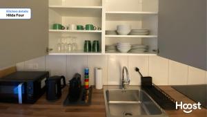 eine Küche mit einer Spüle und einer Theke mit Geschirr in der Unterkunft H4 Family apartment, central, quite, modern in Zürich