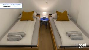 zwei Einzelbetten in einem kleinen Raum mit einem Tisch in der Unterkunft H4 Family apartment, central, quite, modern in Zürich