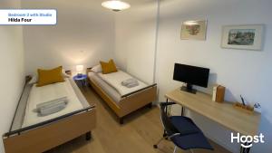 Zimmer mit 2 Betten und einem Schreibtisch mit einem Computer in der Unterkunft H4 Family apartment, central, quite, modern in Zürich