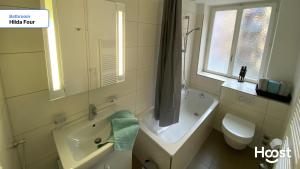 ein Badezimmer mit Badewanne, Waschbecken und Toilette in der Unterkunft H4 Family apartment, central, quite, modern in Zürich