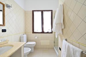 a bathroom with a toilet and a sink at Casa Mariposa in Alghero